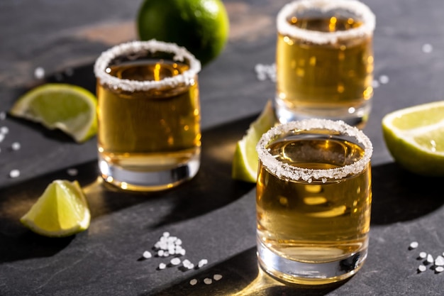 Photo coups de tequila mexicaine dorée avec citron vert et sel boisson nationale mexicaine alcoolisée