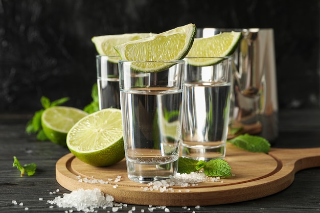 Coups de Tequila avec tranches de citron vert, sel et menthe sur bois