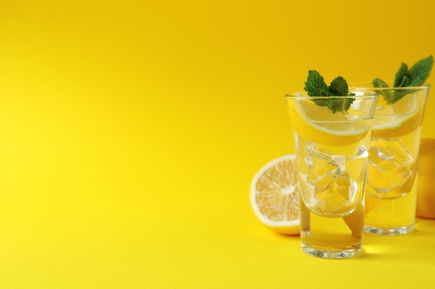 Coups avec tranche de citron et menthe sur une surface jaune