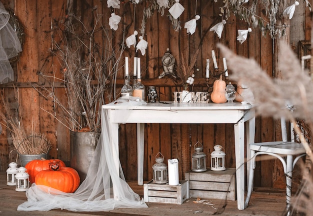 Cour décorée d'Halloween de la vieille maison en bois table blanche vintage avec des bougies et des citrouilles