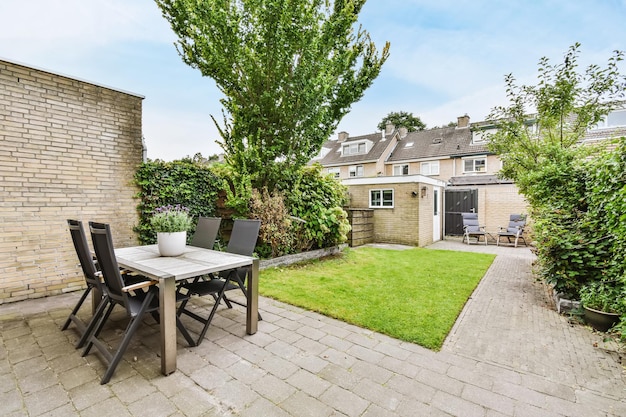 Cour de la maison avec une table chic et des chaises confortables