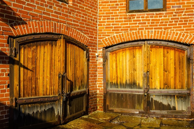 La cour d'un vieux bâtiment en brique avec une porte en bois.