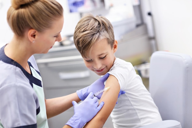 courageux petit garçon recevant une injection ou un vaccin avec un sourire