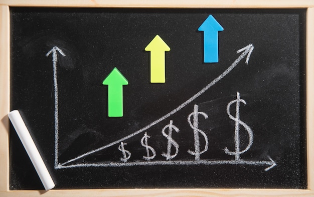 Photo courbe de croissance du dollar sur tableau noir avec des flèches