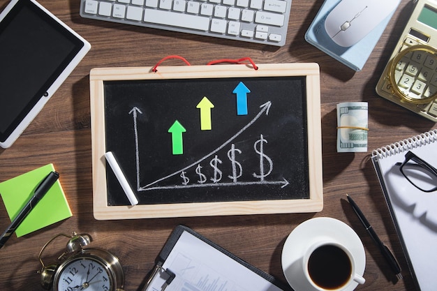 Courbe de croissance du dollar sur tableau noir avec des objets métier