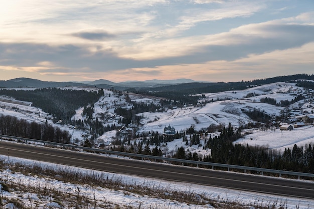 Courbe de la route asphaltée et début de l'hiver dans les montagnes des Carpates Ukraine