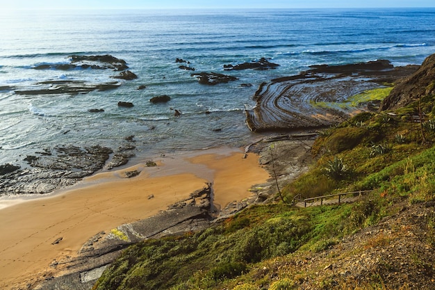 Courbes pierreuses de l'amphithéâtre naturel sur la plage de Carriagem à marée basse Aljezur Algarve Portugal
