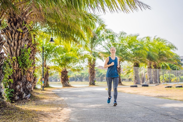 Coureur athlète courant au parc tropical femme fitness lever du soleil jogging entraînement concept de bien-être