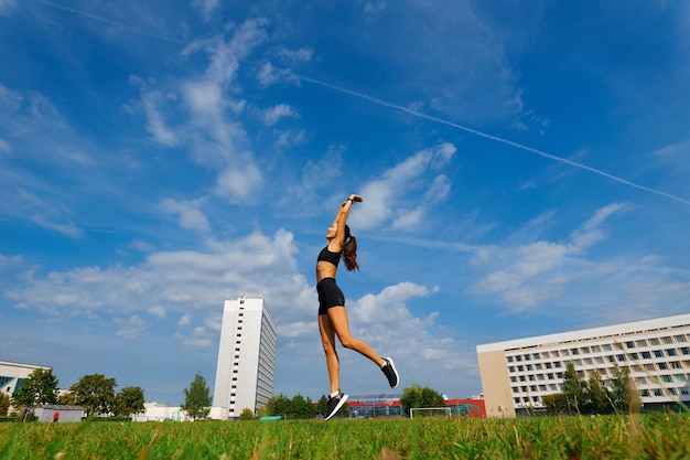 Coureur d'athlète en cours d'exécution sur une piste d'athlétisme entraînant son cardio. Femme jogging pour course de compétition au stade extérieur d'été.