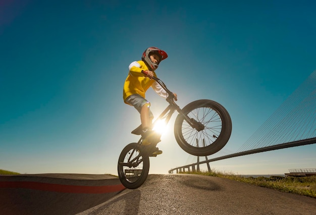 Un coureur de course bmx adolescent effectue des tours dans un parc de skate sur une piste de pompage