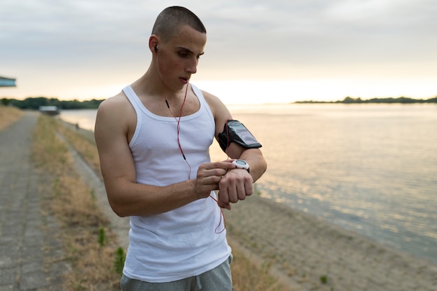 Coureur dans le parc en utilisant la montre intelligente