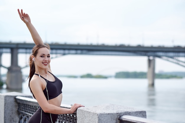 Coureur de femme asiatique en bonne santé de détente après avoir couru à l'extérieur en appréciant la vue sur le front de mer