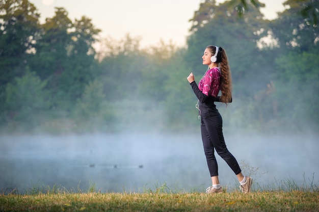 Coureur femme debout près du lac avec un casque