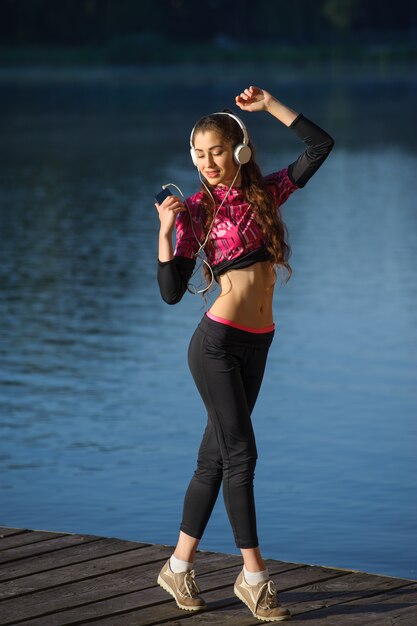 Coureur de femme avec des écouteurs en profitant de la musique en plein air