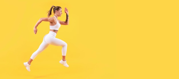 Coureur de femme de remise en forme énergique en cours d'exécution sur fond jaune