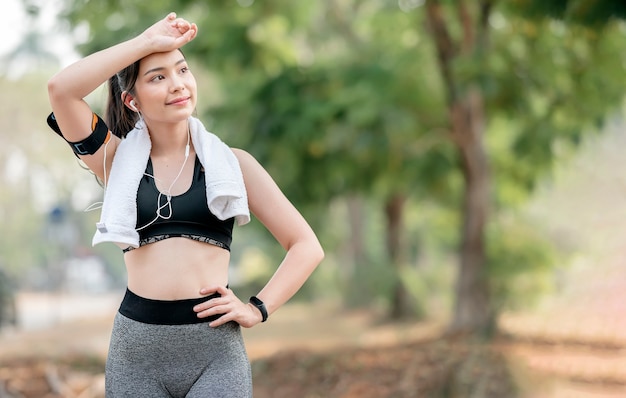 Coureur de femme de remise en forme relaxant après avoir couru et travaillé à l'extérieur.