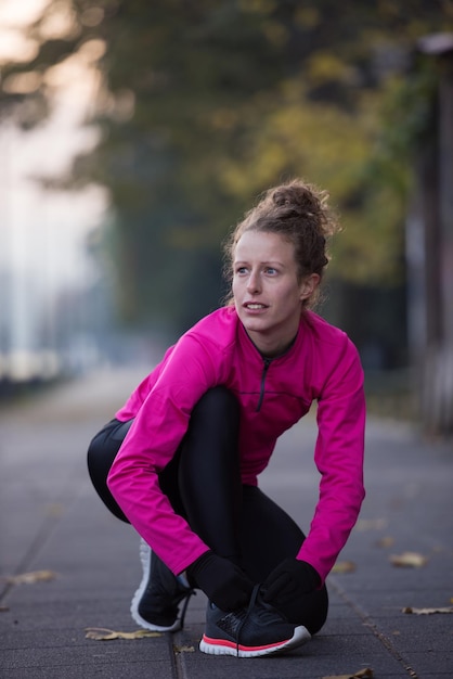 coureur femme s'échauffant et s'étirant avant le jogging du matin