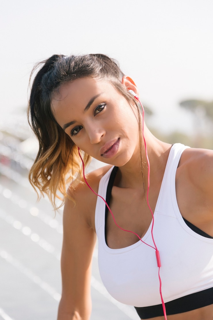 Photo coureur de fille écoutant de la musique sur son brassard avec écran tactile et écouteurs
