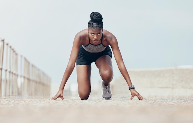 Le coureur de fitness et la femme commencent à courir l'entraînement le long de l'entraînement cardio et de vitesse sur la plage L'exercice sportif et le portrait de la femme noire se préparent pour le marathon avec une concentration sérieuse et intense du matin