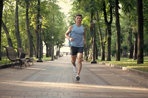 Coureur d'homme athlétique sprintant dans des vêtements de sport en plein air