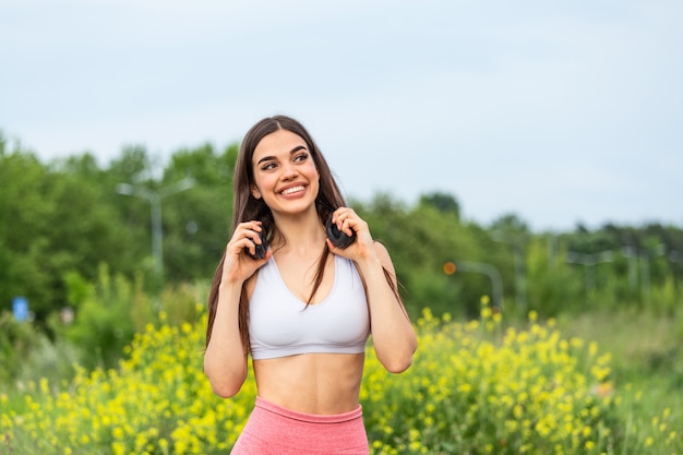 Coureur de la jeune femme écoutant de la musique sur les écouteurs.