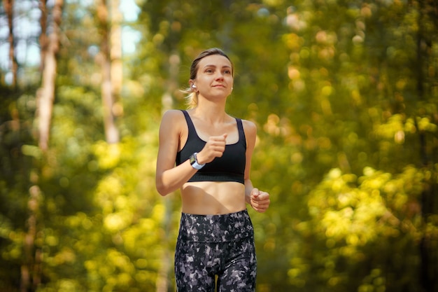 Coureur de jolie jeune fille dans la forêt.