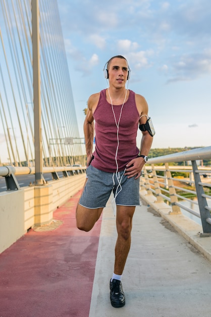 Un coureur masculin étire ses jambes.