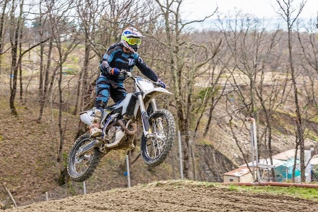 Coureur sur une moto en vol, saute et décolle sur un tremplin