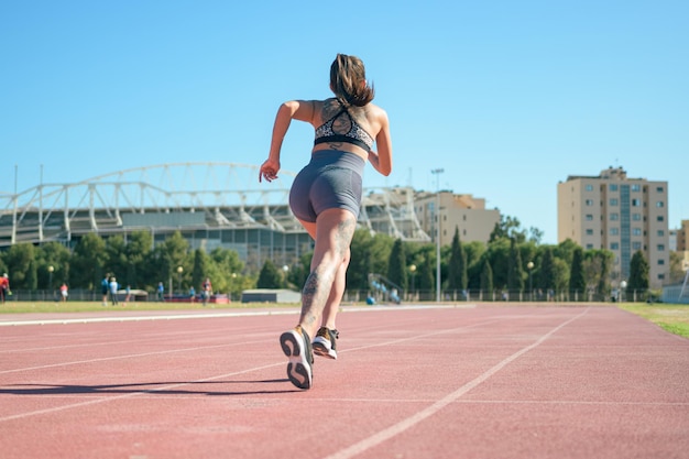 Coureur de remise en forme femme sur piste de course travaillant