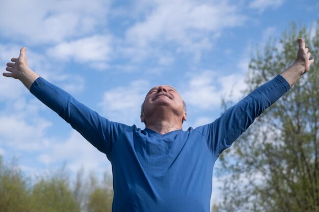 Coureur senior avec brassard faisant des étirements printemps nature