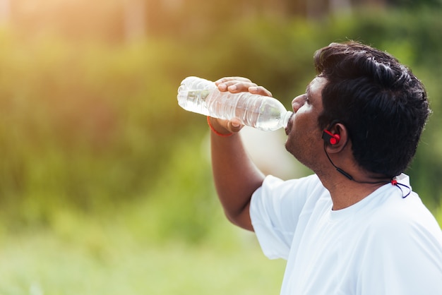 Coureur sport, noir, homme, porter, athlète, écouteurs, il, eau potable, depuis, a, bouteille