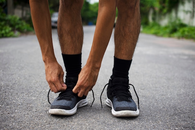 Des coureurs attachés dans des chaussures, un homme qui court dans la rue courent pour faire de l'exercice