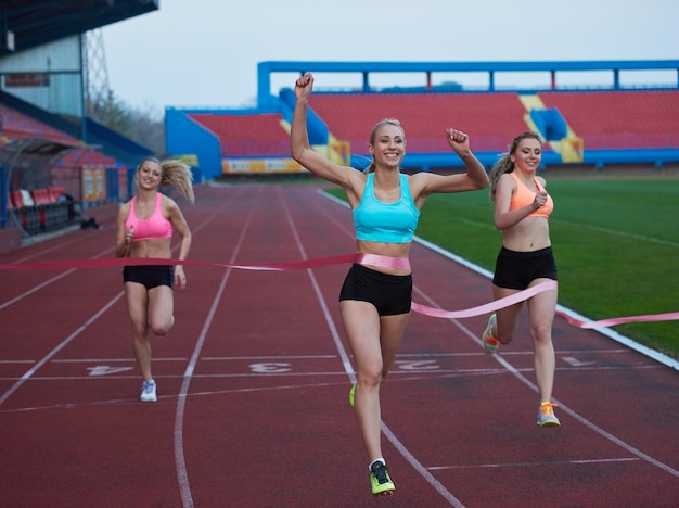Coureurs féminins finissant la course athlétique ensemble