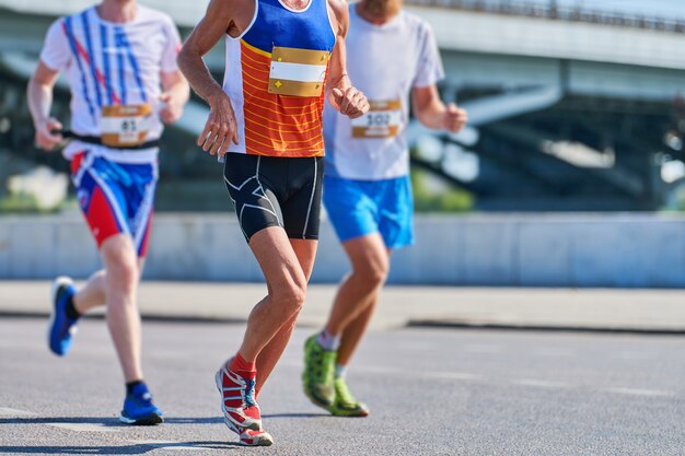 Les coureurs de marathon sur la route de la ville. Compétition en cours.