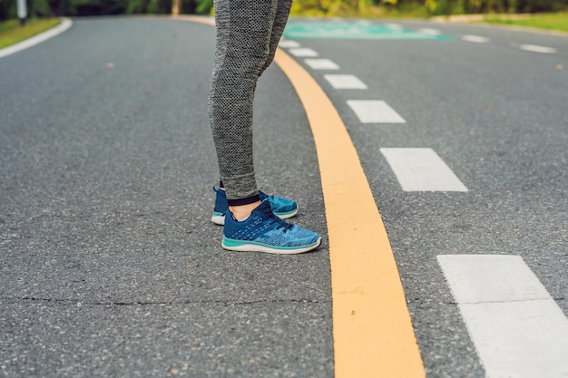 Coureuse attachant ses chaussures se préparant à faire du jogging à l'extérieur de jeune girld runner se prépare pour