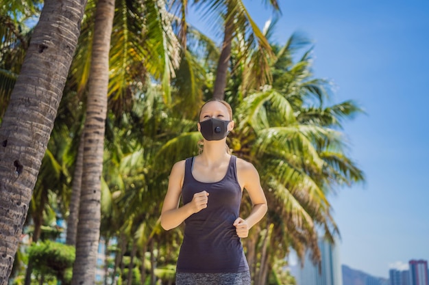 Une coureuse portant un masque médical courant dans le parc pandémie de coronavirus covid sport vie active