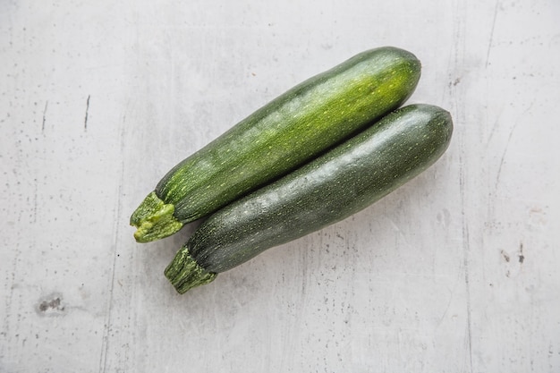 Courgette. Courgettes fraîches sur planche de béton blanc.