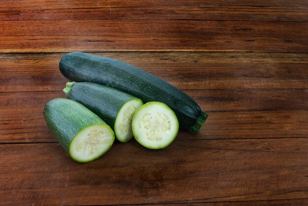 Courgettes bio vertes fraîches sur une table en bois. légumes de saison biologiques.