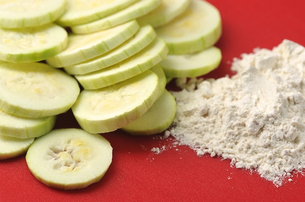 Courgettes coupées en cercles avec de la farine