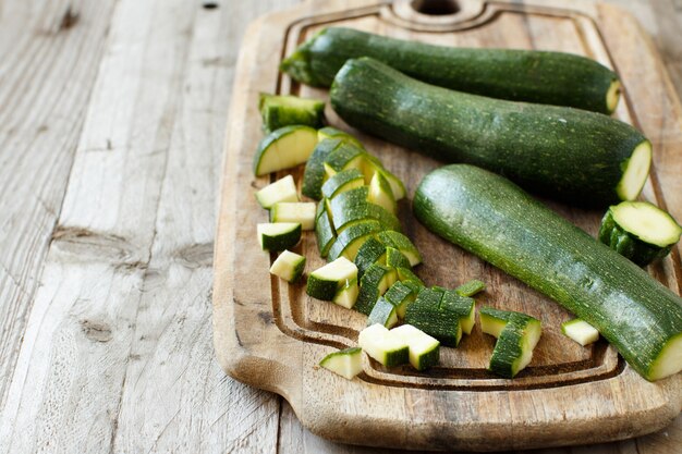 Courgettes fraîches sur une planche de bois se bouchent