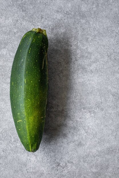 Courgettes jaunes, blanches, dépouillées et vertes mélangées sur un fond en béton gris