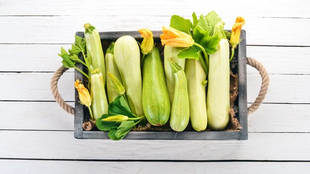 Courgettes à la moelle de courge dans une boîte en bois sur une table blanche Vue de dessus Espace de copie