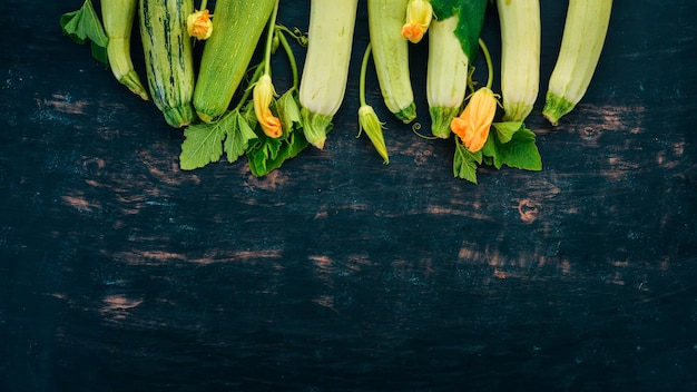 Courgettes à la moelle de courge Légumes frais Sur une table en bois noir Vue de dessus Espace de copie