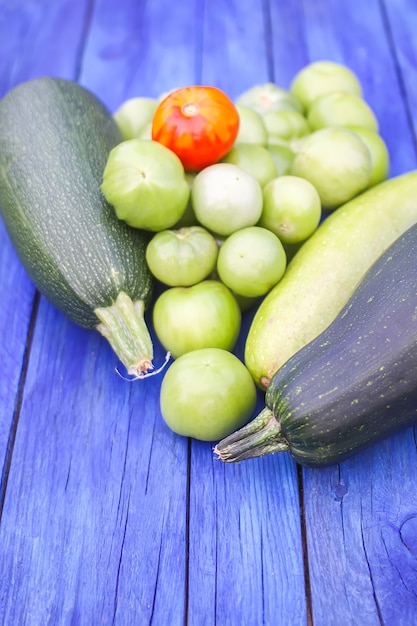 Courgettes et tomates pas mûres. Légumes biologiques crus frais sur des planches de bois à l'extérieur.