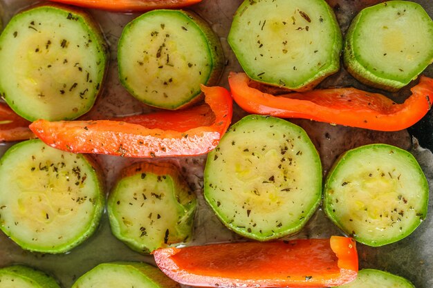 Courgettes tranchées avec poivron à l&#39;huile avec des herbes pour la cuisson.