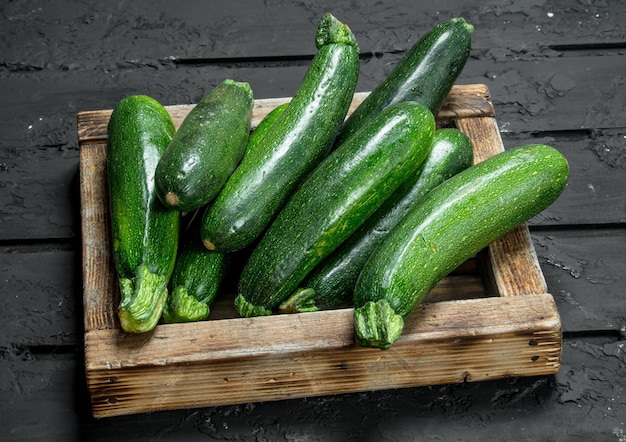 Courgettes vertes dans un plateau en bois