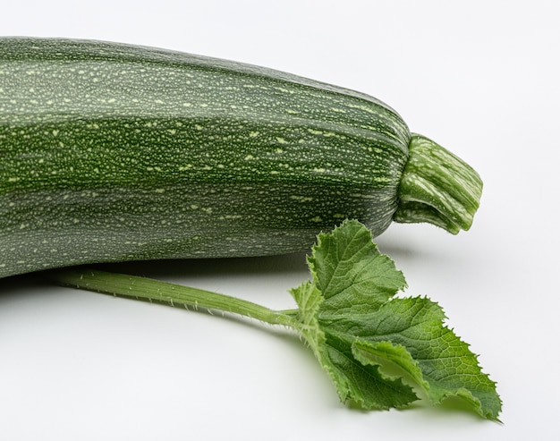 Courgettes vertes avec des feuilles en studio.