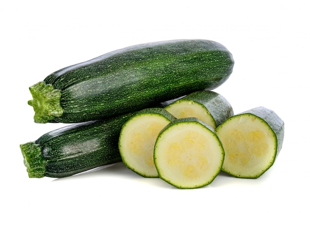 Courgettes vertes fraîches avec tranche isolé sur fond blanc