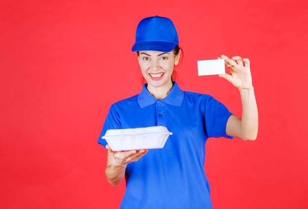 Photo courier femme tenant une boîte à emporter blanche et présentant sa carte de visite.