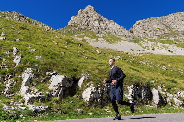 Courir dans les montagnes Trail Athlète masculin sur fond de paysage de montagne